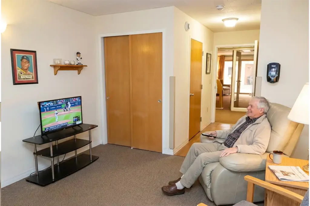 Senior man sitting on a recliner watching a baseball game on TV